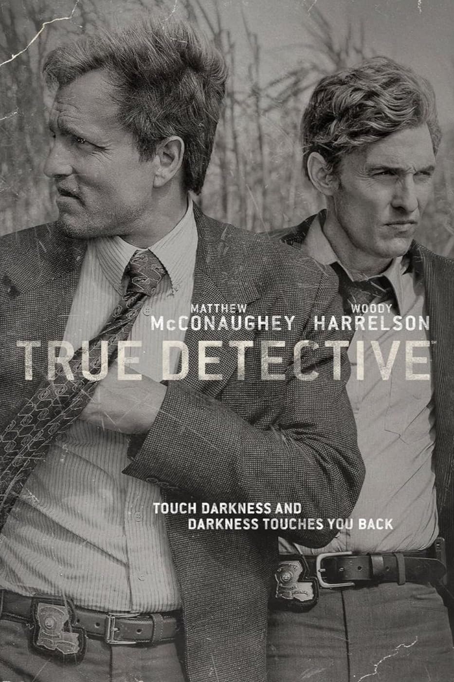 Two men in suits stand in front of dry grass, looking serious. Overlaid text reads Matthew McConaughey, Woody Harrelson, True Detective. Experience the intense atmosphere of this iconic series on Nordic IPTV—touch darkness and darkness touches you back.